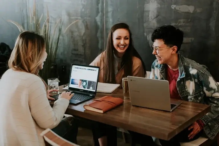 group of people with laptops laughing