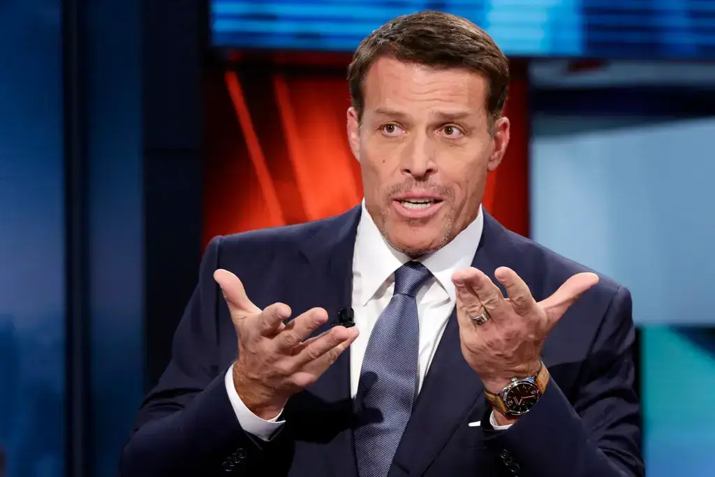 Tony Robbins talking on live tv with hand gestures.