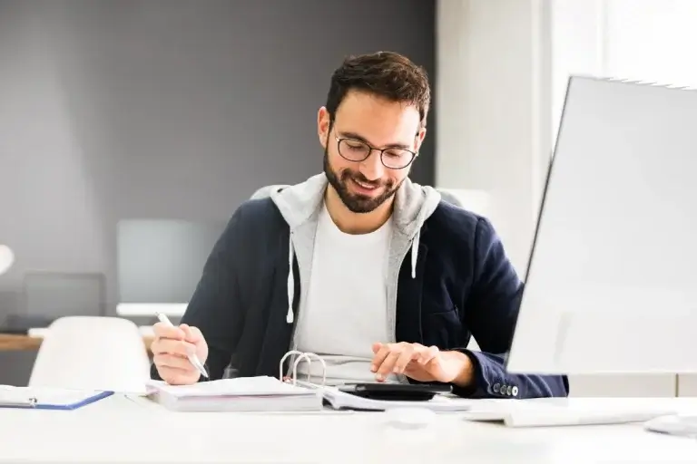 A man shown t o use a calculator to calculate his taxes.